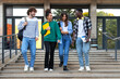 © Daniel - Multiracial happy college students walking together outside university building. Group of young people in college campus