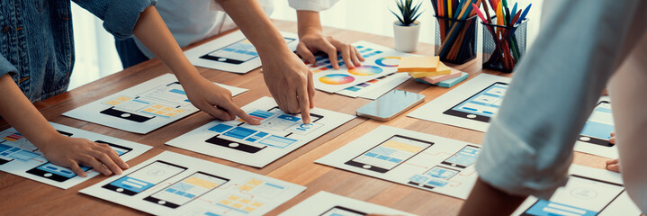 Wall Mural - panorama shot of front-end developer team brainstorming ui and ux designs for mobile app on paper wi