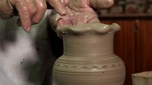 Close-up Of A Potter's Hand Making A Pattern On A Clay Jar On A Potter's Wheel. An Elderly Man Creates Pottery In His Own Workshop Using The Traditional Method.