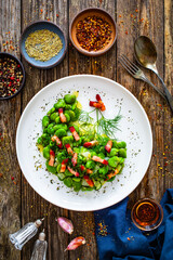 Wall Mural - Broad beans with garlic, dill and bacon on wooden table, top view

