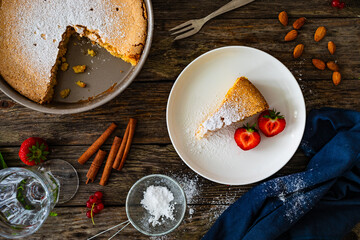 Wall Mural - Torta de Santiago - Spanish almond cake on wooden background, top view