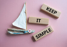 Keep It Simple Symbol. Concept Words Keep It Simple On Wooden Blocks. Beautiful Pink Background With Boat. Business And Keep It Simple Concept. Copy Space.