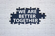 © Natallia - We are better together symbol. White puzzle with words We are better together. Beautiful black background. We are better together concept. Copy space.