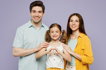 Poster - Young parents mom dad with child kid daughter girl 6 year old wear blue yellow casual clothes show shape heart with hands heart-shape sign, hug isolated on plain purple background Family day concept