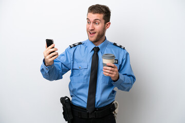 Wall Mural - Young police caucasian man isolated on white background holding coffee to take away and a mobile