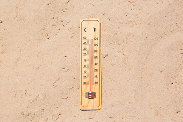 Fototapete - Thermometer on sand showing high temperature. Hot weather and climate concept