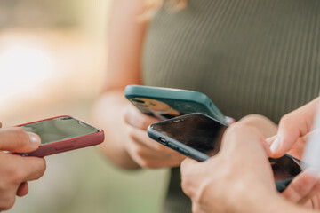 close-up of group of hands of young people with mobile phones