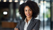 © MP Studio - Close up portrait of a smiling young businesswoman in suit against office background.
