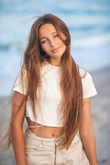 Sticker - Adorable young girl with beautiful long hair enjoy tropical beach vacation. The girl on the seashore at sunset