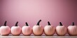 A row of pink pumpkins sitting on top of a wooden table. Halloween decor.
