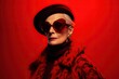 © iridescentstreet - Fashion portrait of stylish senior woman wearing deep red outfit and sunglasses