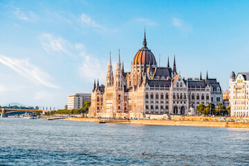 Parliament building in Budapest with fantastic perfect sky and reflection in water. calm Danube river. Popular Travel destinations.