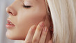 © golubovy - Skincare treatment. Face moisturizing. Freshness beauty. Pretty blonde woman with nude makeup enjoying touching soft flawless perfect radiant skin.