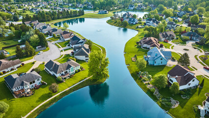 Wall Mural - Split neighborhood with large winding pond with fountain and cul-de-sac housing additions aerial