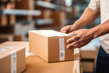 Closeup Of A Man's Hands Taping A Cardboard Box, Preparing It For Shipment In An E-commerce Warehouse