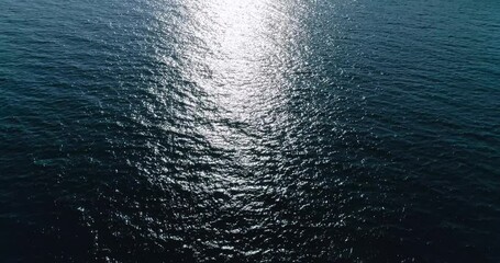 Wall Mural - Aerial top down view from high altitude of blue azure  turquoise sea water texture with sun track,  view of the water surface. Background of the water surface. 4K aerial view