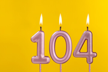 Birthday candle number 104 - Birthday celebration on yellow background