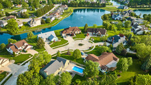 Aerial Two Cul-de-sac Housing Additions With Pond Separating Houses And Water Fountain