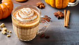 Pumpkin spice latte in a glass mug with cinnamon, nutmeg and cookies