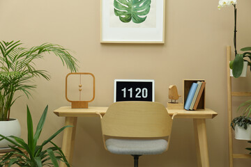 Poster - Stylish workplace with laptop, armchair and houseplants in room. Interior design