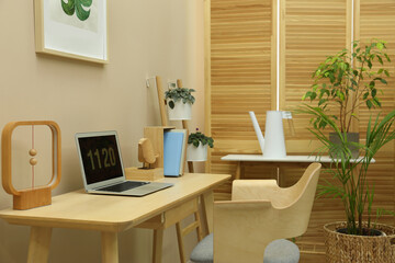 Wall Mural - Stylish workplace with laptop, armchair and houseplants in room. Interior design