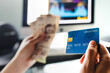 © Marcos - Financial Man holding credit card for shopping online with desktop computer at background in Mexico Latin America