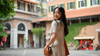 An attractive Asian woman enjoys strolling in the city alone on her weekend. lifestyle concept
