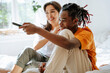 © Westend61 - Happy couple watching TV sitting in bedroom