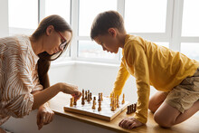 Mother Playing Chess With Son At Home