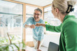 © Westend61 - Happy businessman giving fist bump to businesswoman in office