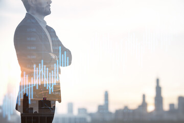 Canvas Print - Successful young businessman silhouette with folded arms using forex chart hologram on blurry city background with mock up city view. Future and financial freedom concept. Double exposure.