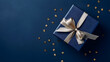 canvas print picture - Dark blue gift box with gold satin ribbon on dark background. Top view of birthday gift with copy space for holiday or Christmas present