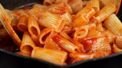 Wall Mural - Chef stir pasta with boiling tomato sauce, close up. Cooking traditional Italian dinner pasta 