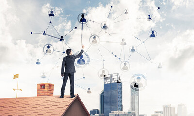 Wall Mural - Businessman on house roof presenting networking and connection c