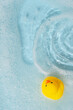 Yellow rubber duck floating on blue water