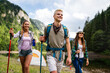 © NDABCREATIVITY - Group of happy friends with backpacks hiking together
