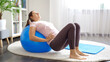 © Кирилл Рыжов - Young woman doing exercises on blue fitball at home. Concept of healthcare, sports and yoga at home.