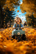 canvas print picture - lachender Junge im Spielzeugauto im Herbst