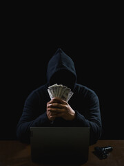 Wall Mural - Hacker spy man one person in black hoodie sitting on a table looking computer laptop used login password attack security to circulate data digital in internet network system, night dark background.