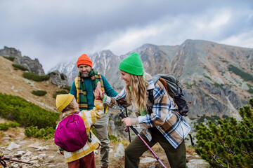 Wall Mural - Happy family hiking together in autumn mountains.