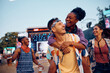 © Drazen - Happy man piggybacking his black girlfriend during open air music concert.
