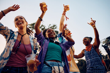 Wall Mural - Below view of happy festival goers enjoy in music concert during summer.