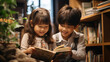 Cute asian little girl and boy reading book together in the library.