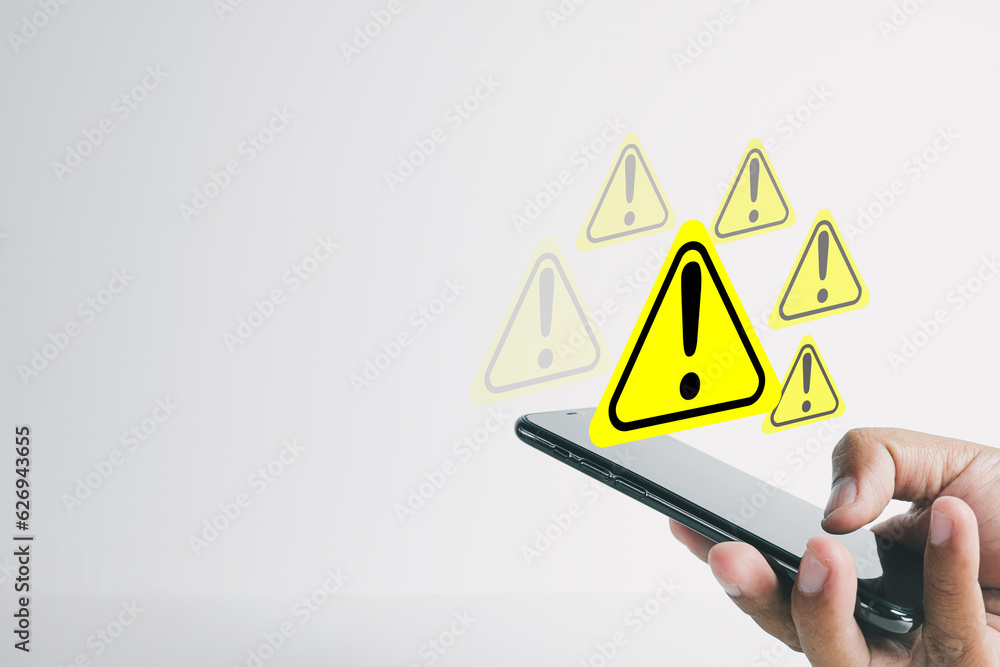 Hand using smartphone with Exclamation mark or Warning sign over white ...