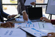 © ArLawKa - The fund manager team consults and discusses stock market analysis by meeting digital tablet business consultants to analyze and discuss the financial report situation in the conference room
