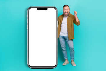 Wall Mural - Photo of successful cheerful man wear stylish clothes demonstrate empty space rejoice discount sale isolated on cyan color background