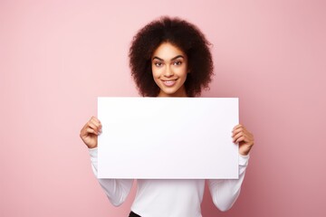a  beautiful black african american woman holding a blank placard sign poster paper in her hands. empty space for editing and ads. isolated on pink pastel background. Generative AI