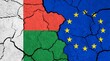 Flags of Madagascar and European Union on cracked surface - politics, relationship concept
