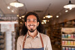 © ADDICTIVE STOCK - Cheerful man standing against lighted supermarket with goods