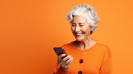 Poster - An elderly woman smiling with her phone against an orange background.